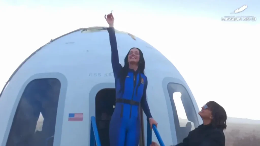 Katy Perry segura uma flor de margarida em direção ao céu, que ela levou ao espaço no voo histórico da Blue Origin.